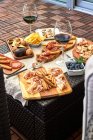 Вид зверху апетитного сорту антипасто, який подається з тарілками на столі на терасі — стокове фото