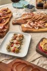 Dall'alto gustosi antipasti assortiti serviti sul tavolo con tovaglia in terrazza — Foto stock