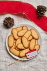 Vista superior da pilha de deliciosos biscoitos de Natal colocados na placa na toalha de mesa para a celebração do feriado — Fotografia de Stock
