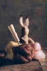 Coniglio pasquale fatto a mano in lana e feltro sul tavolo di legno scuro — Foto stock
