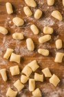 From above top view of uncooked gnocchi placed in rows on lumber table during lunch preparation at home — Stock Photo