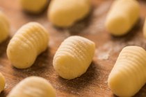 From above top view of uncooked gnocchi placed in organized rows on lumber table during lunch preparation at home — Stock Photo