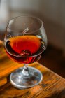 Vetro cognac vecchio stile su tavolo in legno con luce naturale — Foto stock