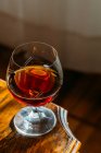 Old fashioned cognac glass on wooden table with natural light — Stock Photo