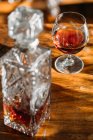 Verre à cognac à l'ancienne sur table en bois avec lumière naturelle — Photo de stock