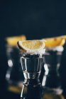 Текила выстрелы с солью и лимоном размещены на отражающей поверхности на темном фоне — стоковое фото