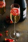 Still life composition of champagne cocktail with pomegranate on a rustic surface — Stock Photo