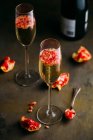 Stillleben-Komposition aus Champagner-Cocktail mit Granatapfel auf rustikaler Oberfläche — Stockfoto