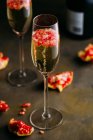 Natura morta composizione di cocktail di champagne con melograno su una superficie rustica — Foto stock