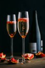 Cocktail di champagne con melograno posto su superficie rustica su fondo scuro — Foto stock