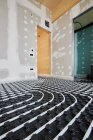Hoher Winkel der Heizungsanlagen mit Rohren, die auf dem Fußboden in einem modernen Holzhaus installiert sind — Stockfoto