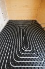 Alto ângulo de sistemas de aquecimento radiante com tubos instalados no chão na casa de campo de madeira contemporânea — Fotografia de Stock