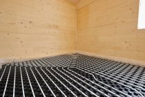 Angolo alto di sistemi di riscaldamento radiante con tubi installati a pavimento in cottage in legno contemporaneo — Foto stock