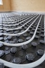 High angle of radiant heating systems with pipes installed on floor in contemporary wooden cottage — Stock Photo