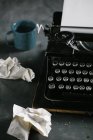 Máquina de escribir retro vintage de pie sobre una vieja mesa de madera - foto de stock