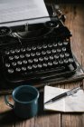 Máquina de escribir retro vintage de pie sobre una vieja mesa de madera - foto de stock
