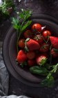 Вид зверху миски зі свіжою полуницею та помідорами для приготування гапчастого холодного супу, розміщеного на темному столі — стокове фото
