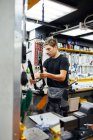 Focused male master with bike frame working in modern repair workshop — Stock Photo