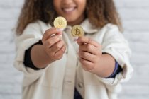Unerkennbares schwarzes Mädchen hält Kryptowährung in Händen — Stockfoto