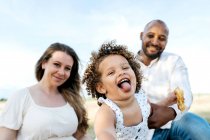 Щаслива багатоетнічна сім'я з милою маленькою дочкою насолоджується літнім пікніком на природі — стокове фото