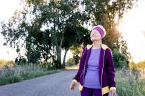 Atleta anziana a occhi chiusi che respira aria fresca durante un allenamento di fitness in campagna — Foto stock