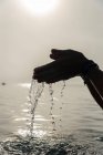 Cortar fêmea sem rosto com punhado de água em mãos molhadas no mar de manhã em Alcudia — Fotografia de Stock