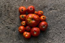 Vista superior primer plano de una pila de tomates rojos en el suelo - foto de stock