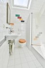 Interior do banheiro em casa com espelho pendurado sobre lavatório colocado perto da porta de entrada e cabine de chuveiro de vidro no apartamento moderno — Fotografia de Stock