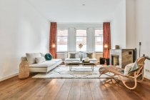 Interior de salão espaçoso com lareira e confortável sofá e poltronas na casa contemporânea — Fotografia de Stock