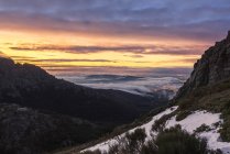 Paisaje de crestas escarpadas ásperas bajo el cielo nublado de la puesta del sol en la noche de invierno en las tierras altas - foto de stock