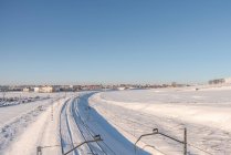 Drohnenblick auf Zug auf verschneitem Gelände bei blauem Himmel — Stockfoto