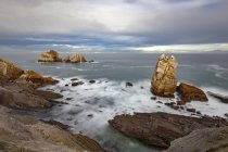 Paysage spectaculaire avec des vagues de mer mousseuses lavant des formations rocheuses rugueuses de différentes formes Costa Quebrada en Cantabrie, Espagne — Photo de stock