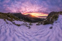 Scenic landscape of rocky mountains in Sierra de Guadarrama National Park covered with snow under bright sun at sunset — Stock Photo