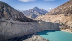 Paysage de lac bleu entouré de montagnes rocheuses avec des pentes raides dans une vaste vallée au Népal — Photo de stock