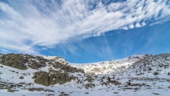 Мальовничі пейзажі скелястих гір, вкритих снігом, розташовані в сільській місцевості під хмарним блакитним небом в денне світло — стокове фото