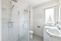 Cabine de douche et toilettes en carrelage blanc salle de bain conçue dans un style minimal dans un appartement contemporain — Photo de stock