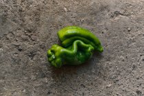Top view close-up of two green peppers on the ground — Stock Photo