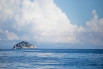 Paisagem de mar ondulante azul claro com ilha rochosa no horizonte sob nuvens em dia ensolarado na Malásia — Fotografia de Stock