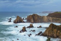 Spektakuläre Szenerie mit schäumenden Meereswellen, die raue Felsformationen in verschiedenen Formen am Silence Beach in Asturien spülen — Stockfoto