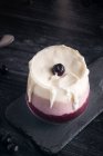 Стакан вкусного бананового и черничного смузи со взбитыми сливками на доске против банки йогурта и металлического ведра — стоковое фото