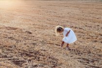 Kleines blondes Mädchen allein auf einem Feld an einem sonnigen Tag — Stockfoto