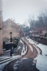 Leere enge gepflasterte Straße im historischen Viertel von Paris mit der Basilika Sacre Coeur im Nebel am Wintertag — Stockfoto