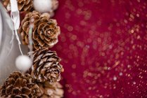 Свеча в стеклянном держателе украшена конусами и звездами, поставленными на стол для празднования Рождества — стоковое фото