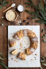 Overhead view of tasty three kings cake decorated with almond petals and coconut flakes among Eucalyptus and fir sprigs — Stock Photo