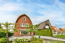 Asphalt roadway against dwelling building exteriors and meadows with trees under cloudy sky in Utrecht Netherlands — Stock Photo