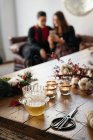 Positive women friends sitting on sofa and laughing while browsing smartphone in room with Christmas decorations in daytime — Stock Photo