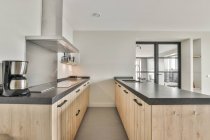 Interior da zona de cozinha com armários de madeira no apartamento contemporâneo com design minimalista — Fotografia de Stock