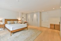 Interior do quarto moderno com cama confortável e grande armário em novo apartamento — Fotografia de Stock