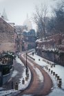 Route pavée étroite vide dans le quartier historique de Paris avec la basilique du Sacré-Cœur dans la brume en journée d'hiver — Photo de stock