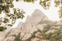 Dal basso delle alte cime della catena montuosa di Montserrat ricoperta di piante in Spagna — Foto stock